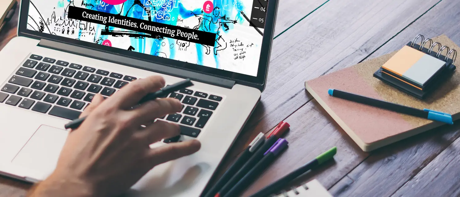 Working on a laptop, with a notebook and pens next to it