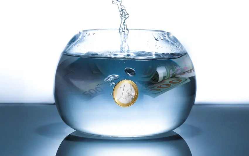 Geld, das in einer Goldfisch-Schüssel versinkt