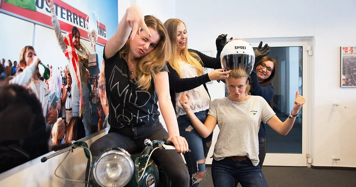 Vier Auszubildende von DRIVE auf und neben Motorrad